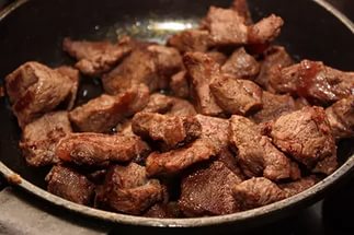 Говядина отборная, разделанная, нарезаная кусками, мясо с жиром убранным до уровня1/8", приготовленная
